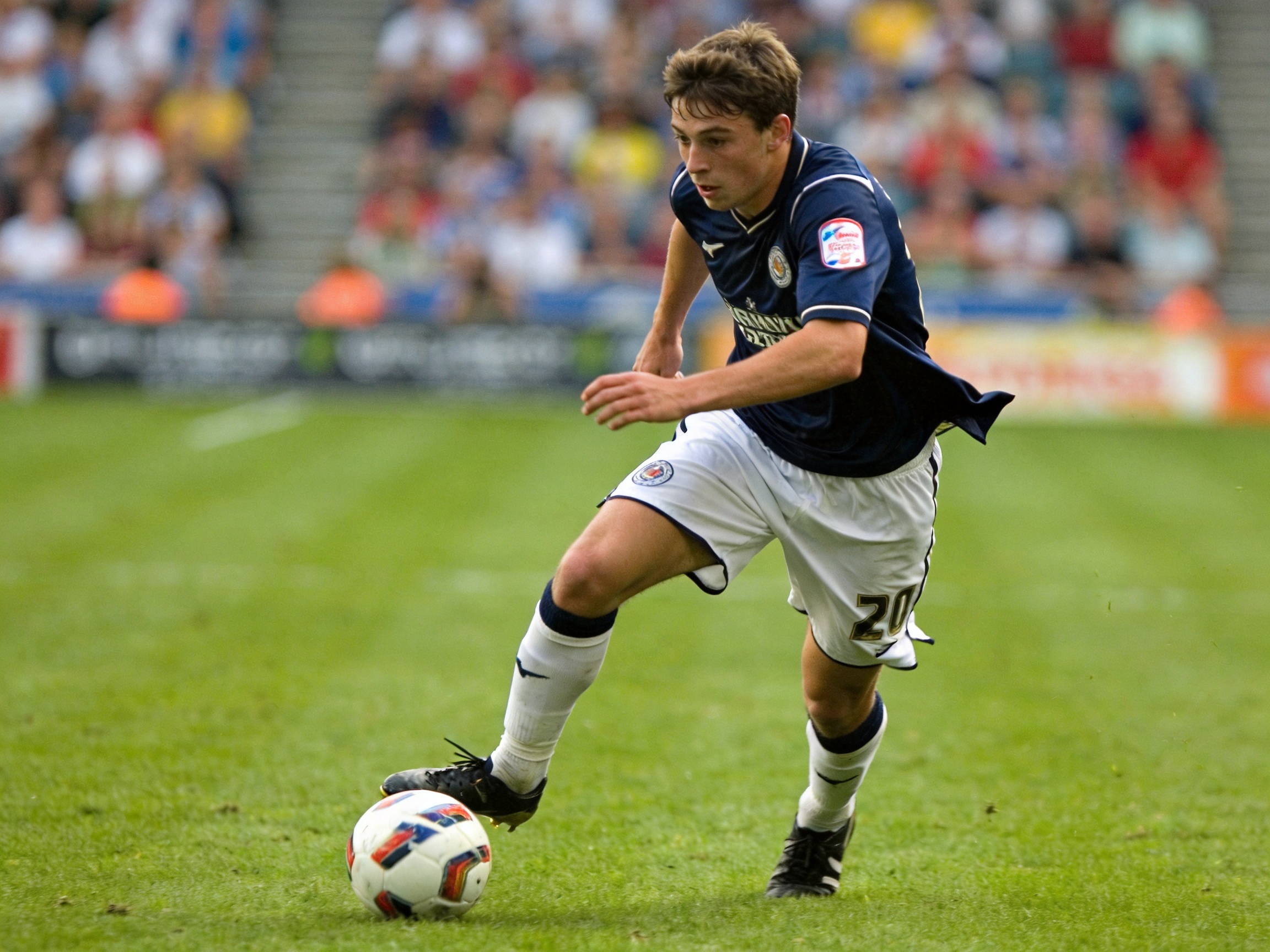 足球运动员在比赛中带球推进,用于年轻中场球员观察文章配图